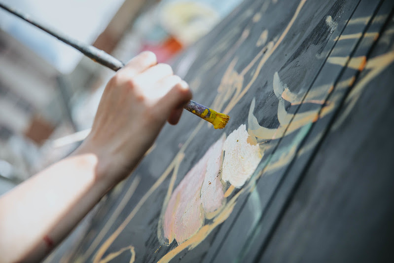 Un joven pinta un mural en el marco de una actividad cultural de la FUGA