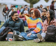 tres jóvenes disfrutando de un evento sentados y charlando entre ellos