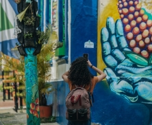 Fotografía de una mujer fotografiando un mural con su celular